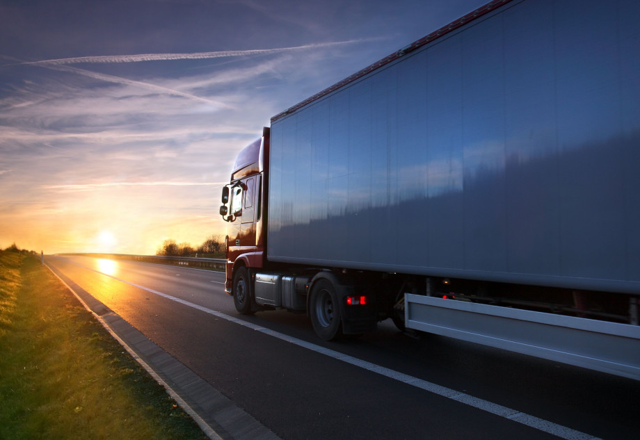 Freight Truck driving towards the low-hanging setting sun